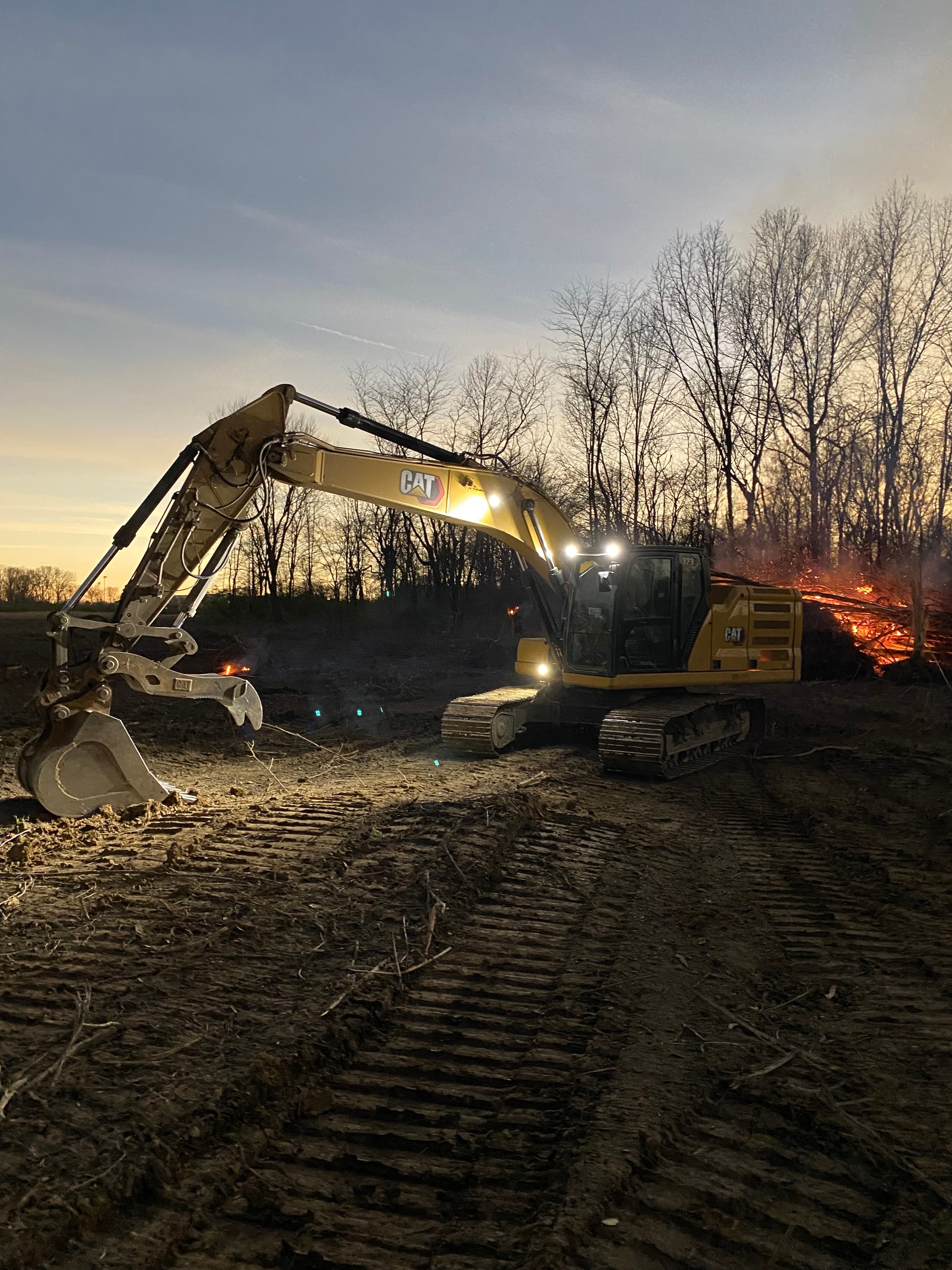 CAT excavator working at dusk on job site
